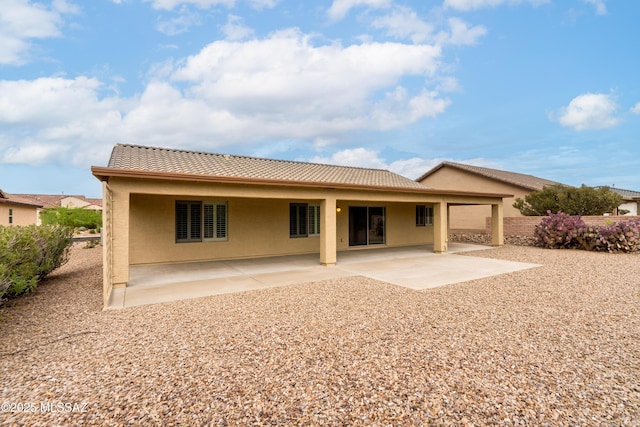 back of property featuring a patio area, a tile roof, and stucco siding