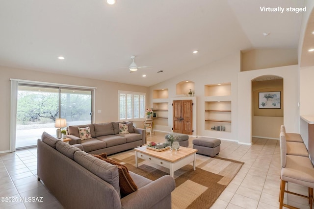 living room featuring vaulted ceiling, a ceiling fan, light tile patterned flooring, baseboards, and built in features