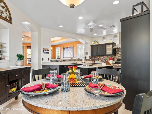 dining room featuring visible vents, a ceiling fan, recessed lighting, and arched walkways