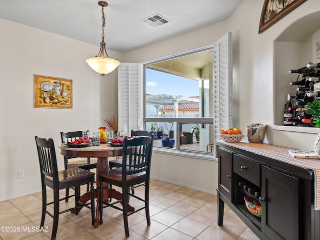 dining room featuring light tile patterned floors, visible vents, and baseboards