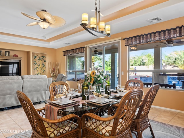 dining area with visible vents, a raised ceiling, a ceiling fan, and light tile patterned floors