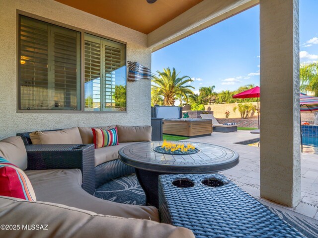 view of patio / terrace with fence and an outdoor living space with a fire pit