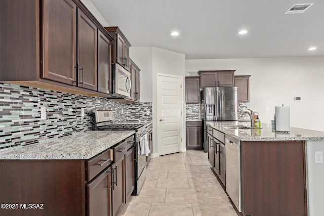 kitchen with dark brown cabinets, stainless steel appliances, visible vents, and a sink