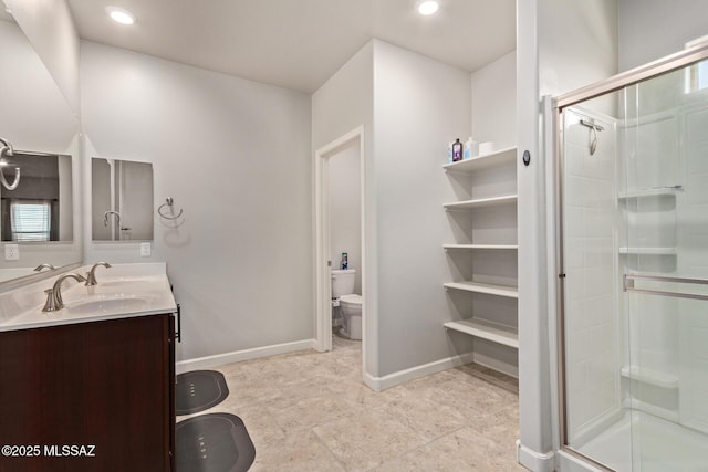 full bathroom with a sink, a shower stall, double vanity, and toilet