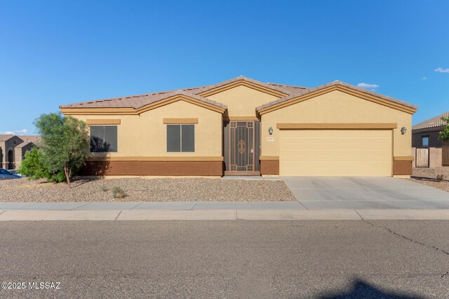 ranch-style house featuring a garage, a tile roof, driveway, and stucco siding