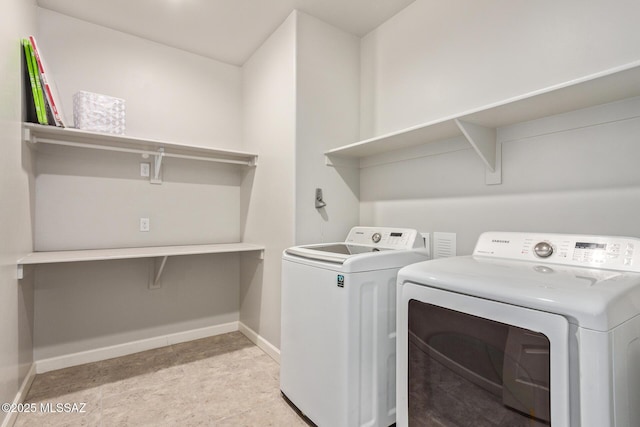 laundry area with washing machine and clothes dryer, laundry area, and baseboards