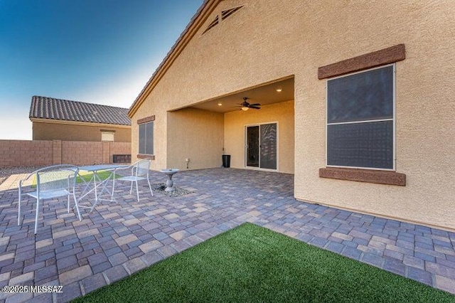 view of patio with fence, a ceiling fan, outdoor dining area, and visible vents