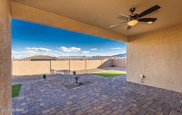 view of patio with a fenced backyard and a ceiling fan