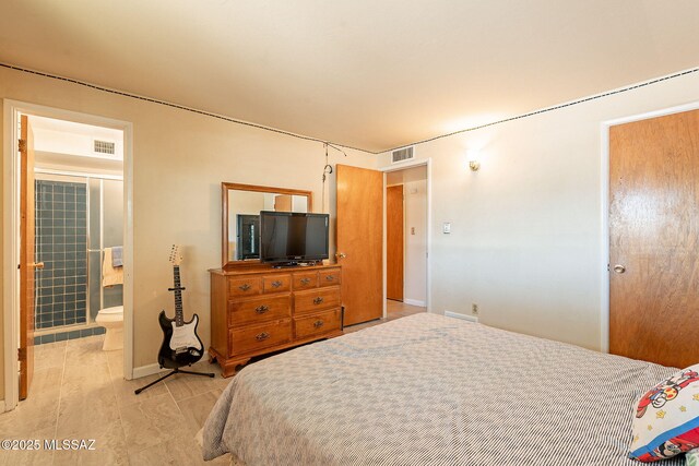 bedroom with baseboards, ensuite bath, and visible vents