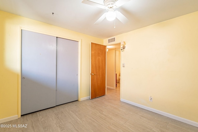 unfurnished bedroom featuring a closet, visible vents, light wood finished floors, and baseboards