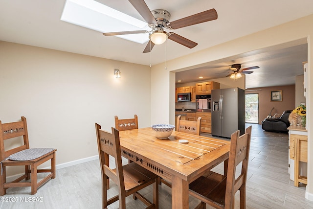 dining space featuring light wood-style floors, baseboards, and ceiling fan