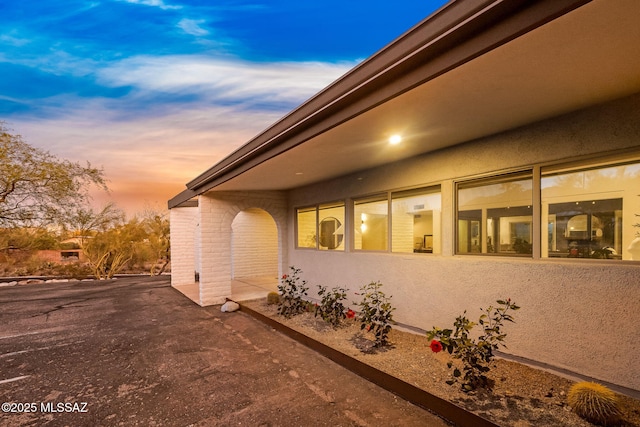 3855 N Via Avellana, Tucson, AZ 85718 - property exterior at dusk featuring stucco siding and a patio area