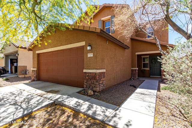 9528 S Desert Fauna Loop, Tucson, AZ 85747 - view of front of house with stucco siding, stone siding, concrete driveway, and a garage