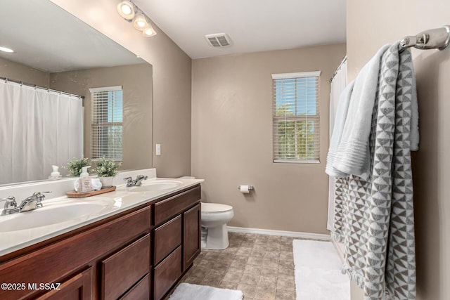 9528 S Desert Fauna Loop, Tucson, AZ 85747 - full bathroom with baseboards, toilet, a sink, and visible vents