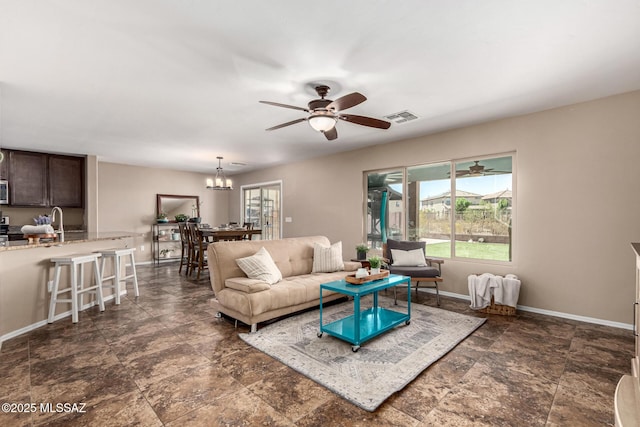 9528 S Desert Fauna Loop, Tucson, AZ 85747 - living area featuring ceiling fan with notable chandelier, baseboards, visible vents, and stone finish flooring