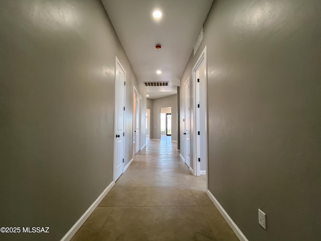 corridor featuring recessed lighting, baseboards, concrete floors, and visible vents