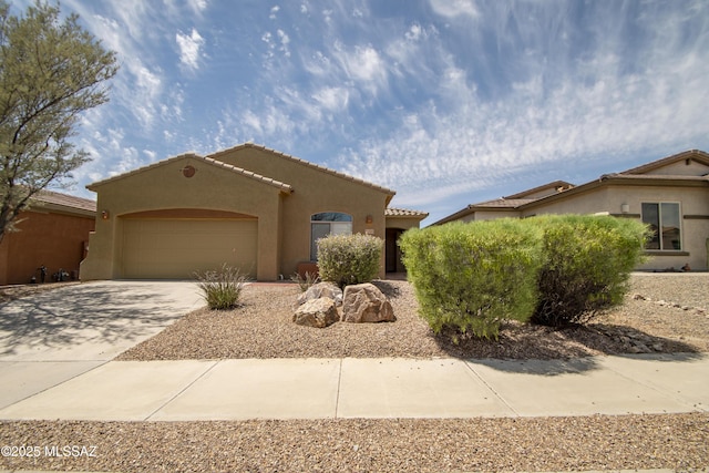 view of front facade with stucco siding, a tile roof, driveway, and a garage