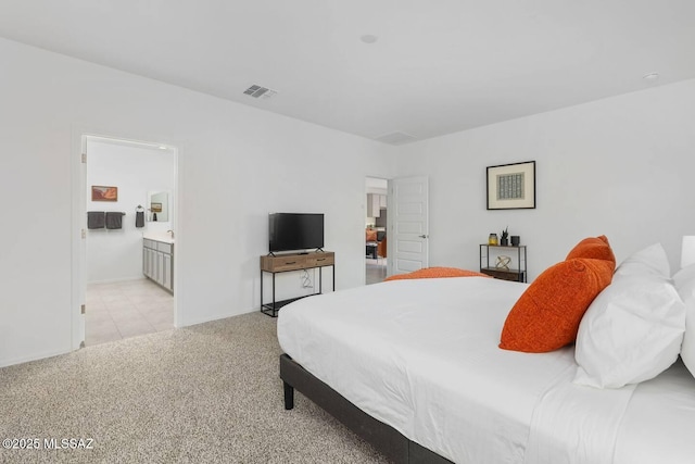 bedroom with visible vents and connected bathroom