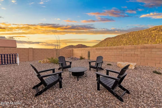 view of patio / terrace with a fenced backyard, a fire pit, and a mountain view