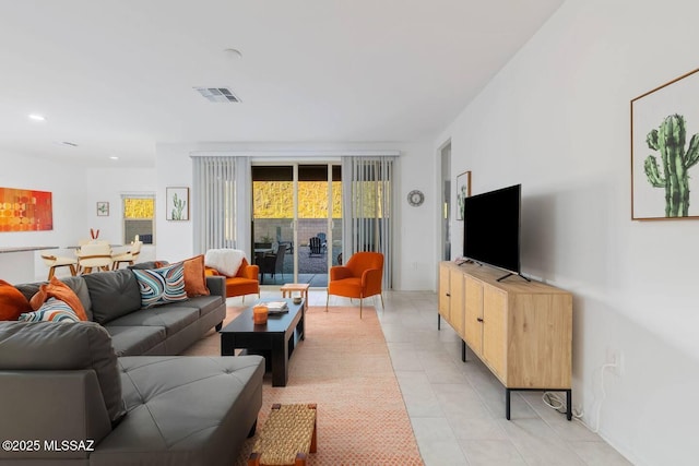living room with light tile patterned flooring, visible vents, and recessed lighting