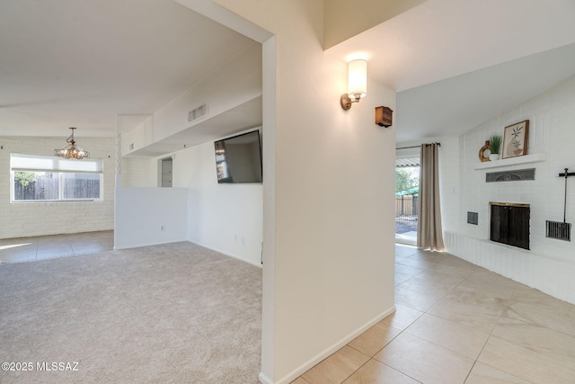 2826 W Jacinto St, Tucson, AZ 85745 - unfurnished living room with a large fireplace, tile patterned flooring, and a chandelier