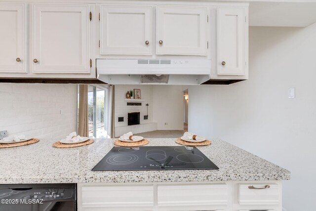 2826 W Jacinto St, Tucson, AZ 85745 - kitchen with under cabinet range hood, black electric cooktop, dishwashing machine, and white cabinetry