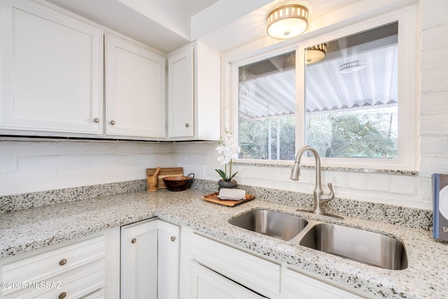 2826 W Jacinto St, Tucson, AZ 85745 - kitchen with a sink, white cabinetry, and backsplash