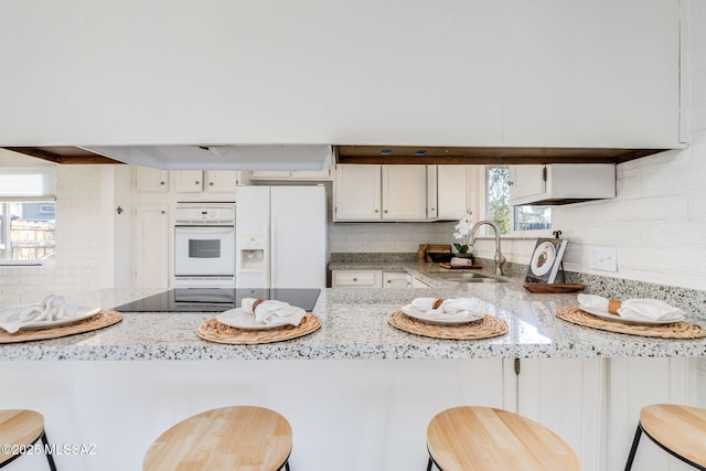 2826 W Jacinto St, Tucson, AZ 85745 - kitchen with white appliances, a sink, a peninsula, and backsplash