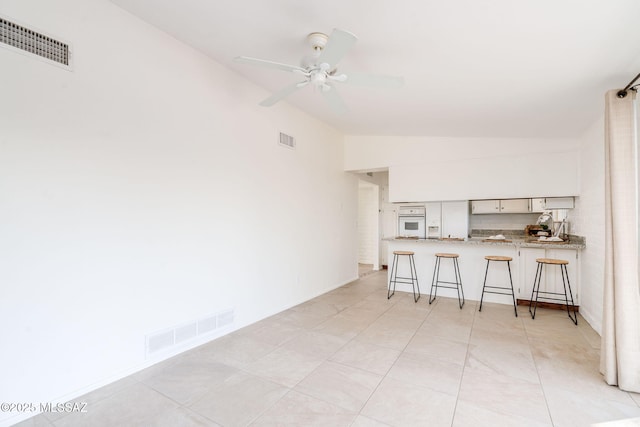 2826 W Jacinto St, Tucson, AZ 85745 - kitchen featuring oven, lofted ceiling, a kitchen breakfast bar, a peninsula, and a ceiling fan