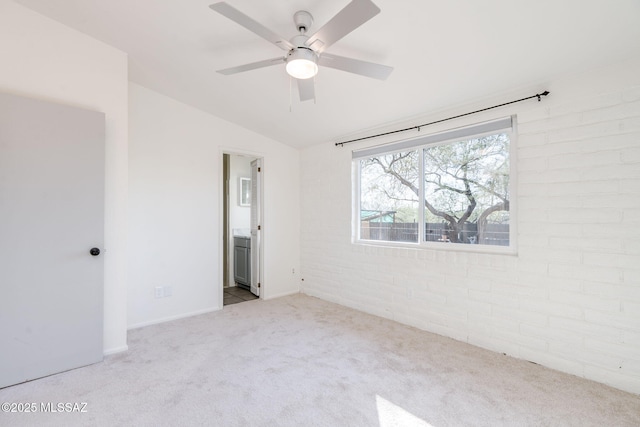 2826 W Jacinto St, Tucson, AZ 85745 - unfurnished bedroom featuring carpet, lofted ceiling, brick wall, ensuite bath, and baseboards