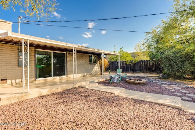 2826 W Jacinto St, Tucson, AZ 85745 - rear view of property featuring a patio area, a fire pit, brick siding, and fence