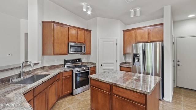 12693 N Rye Dr, Marana, AZ 85653 - kitchen with appliances with stainless steel finishes, a sink, light stone counters, light tile patterned flooring, and brown cabinets