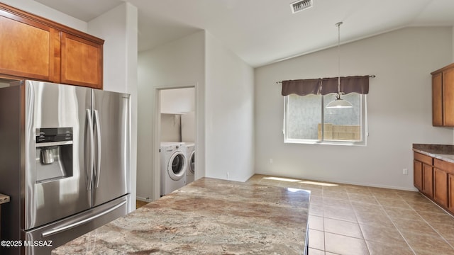 12693 N Rye Dr, Marana, AZ 85653 - kitchen with stainless steel refrigerator with ice dispenser, washer and dryer, brown cabinets, vaulted ceiling, and light stone countertops