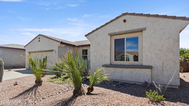 12693 N Rye Dr, Marana, AZ 85653 - view of property exterior featuring an attached garage, stucco siding, and driveway