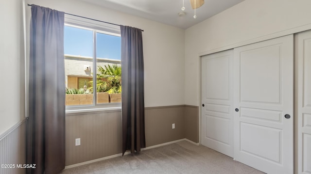 12693 N Rye Dr, Marana, AZ 85653 - unfurnished bedroom with multiple windows, a closet, light colored carpet, and wainscoting