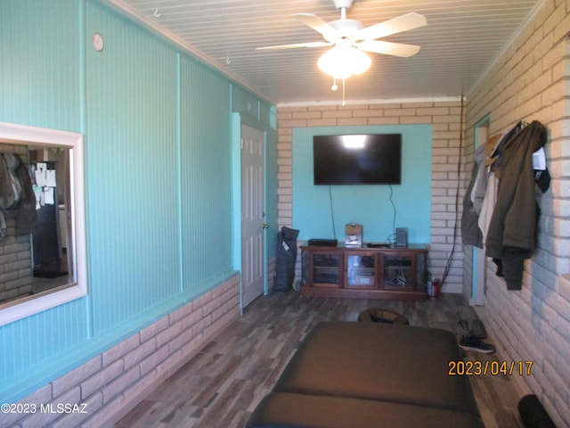 2583 W Arcadia Ln, Willcox, AZ 85643 - living room featuring brick wall, a ceiling fan, and wood finished floors
