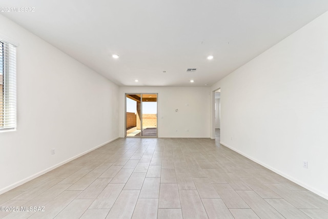empty room with recessed lighting, visible vents, and baseboards
