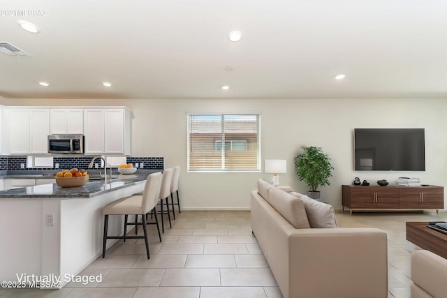 living room with recessed lighting, visible vents, baseboards, and light tile patterned floors