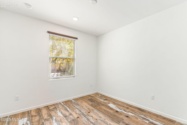 spare room featuring wood finished floors and baseboards