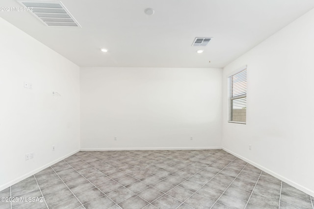 unfurnished room featuring baseboards, visible vents, and recessed lighting