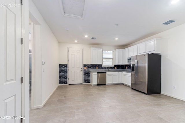 kitchen with white cabinets, decorative backsplash, stainless steel appliances, and visible vents