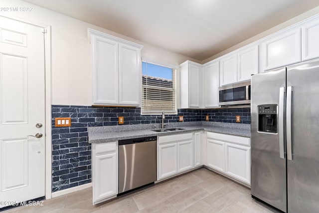 kitchen featuring backsplash, a sink, white cabinetry, and appliances with stainless steel finishes