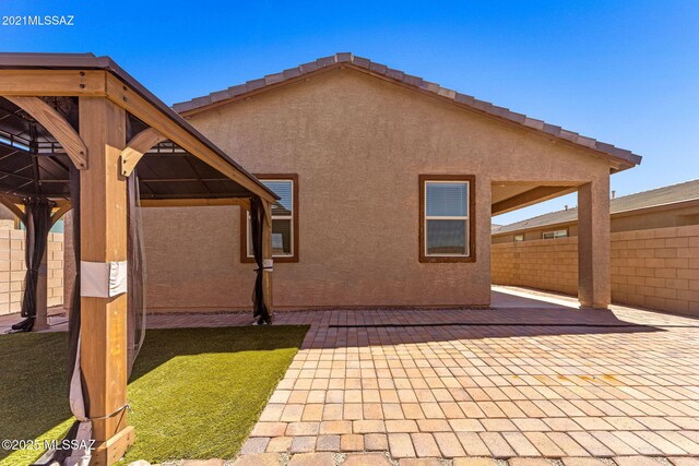 back of property featuring a patio, stucco siding, and fence