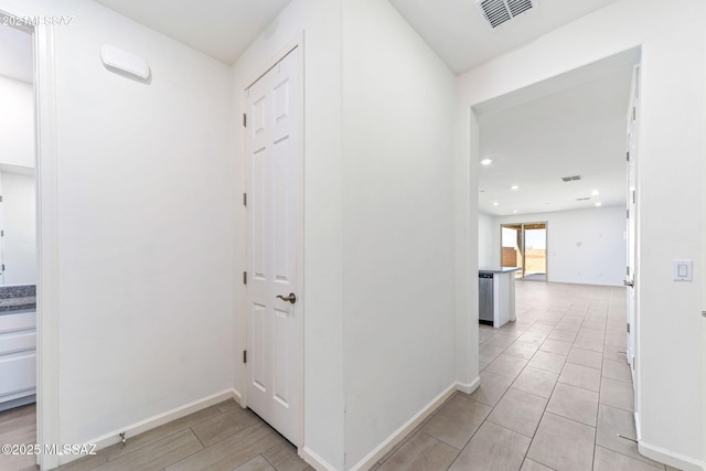 hall with recessed lighting, visible vents, and baseboards