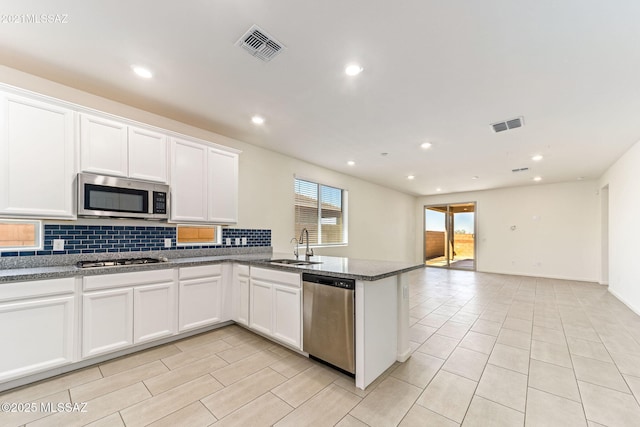 kitchen featuring visible vents, decorative backsplash, stainless steel appliances, and a sink