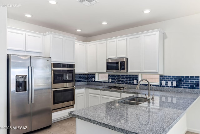 kitchen featuring white cabinets, stainless steel appliances, a peninsula, and visible vents