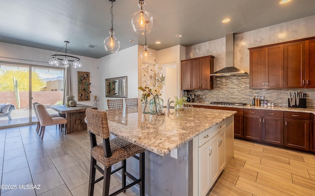 13274 Humphreys Peak Dr, Oro Valley, AZ 85755 - kitchen featuring a breakfast bar area, light stone counters, wall chimney range hood, and tasteful backsplash