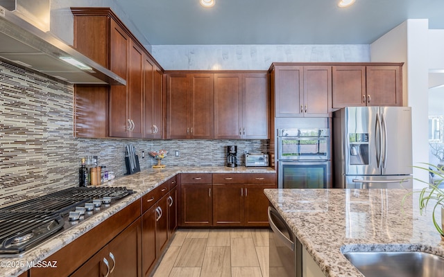 13274 Humphreys Peak Dr, Oro Valley, AZ 85755 - kitchen with wall chimney range hood, light stone counters, stainless steel appliances, and backsplash
