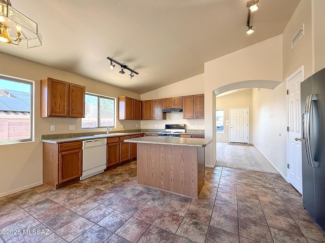 2582 W Brandy Crest Dr, Tucson, AZ 85713 - kitchen with white appliances, rail lighting, under cabinet range hood, arched walkways, and baseboards