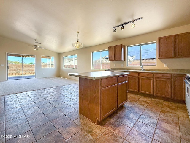 2582 W Brandy Crest Dr, Tucson, AZ 85713 - kitchen with brown cabinets, a sink, open floor plan, a ceiling fan, and vaulted ceiling